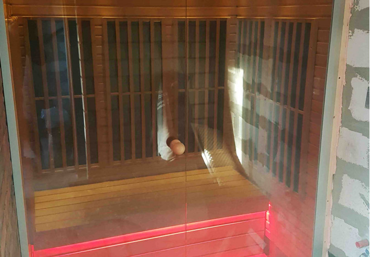 Infraroodsauna met glazen voorkant en ledverlichting.