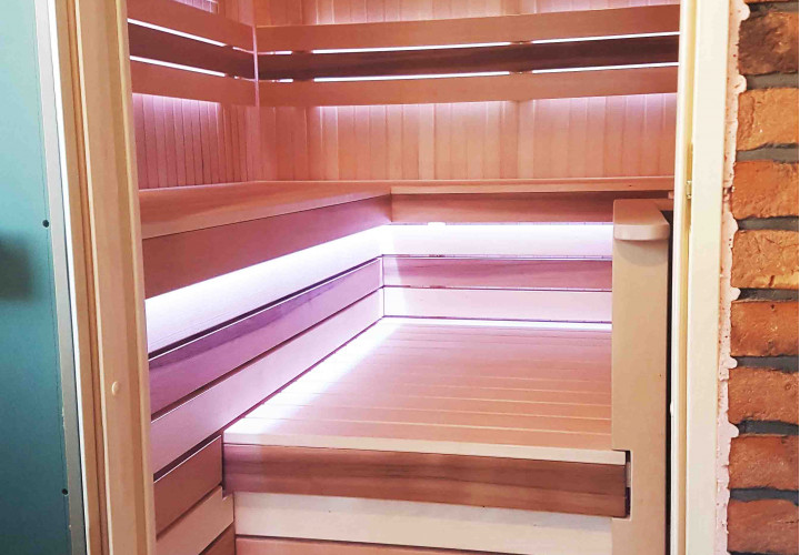 Sauna met houtkachel en externe vuurhaard.