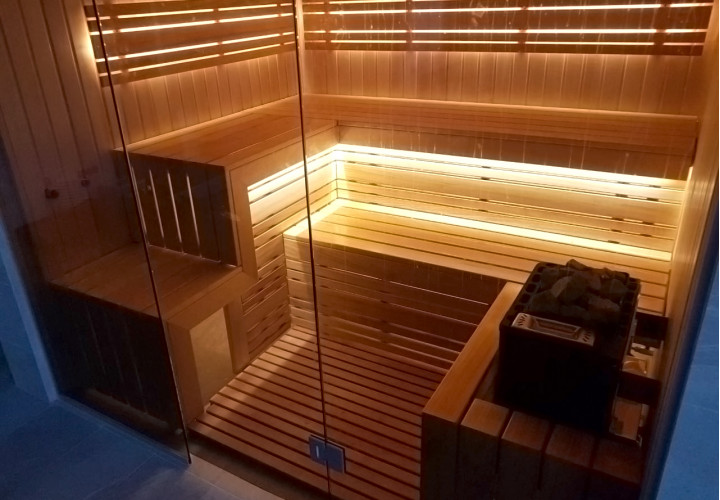 Sauna met glazen wanden en uitzicht op het zwembad