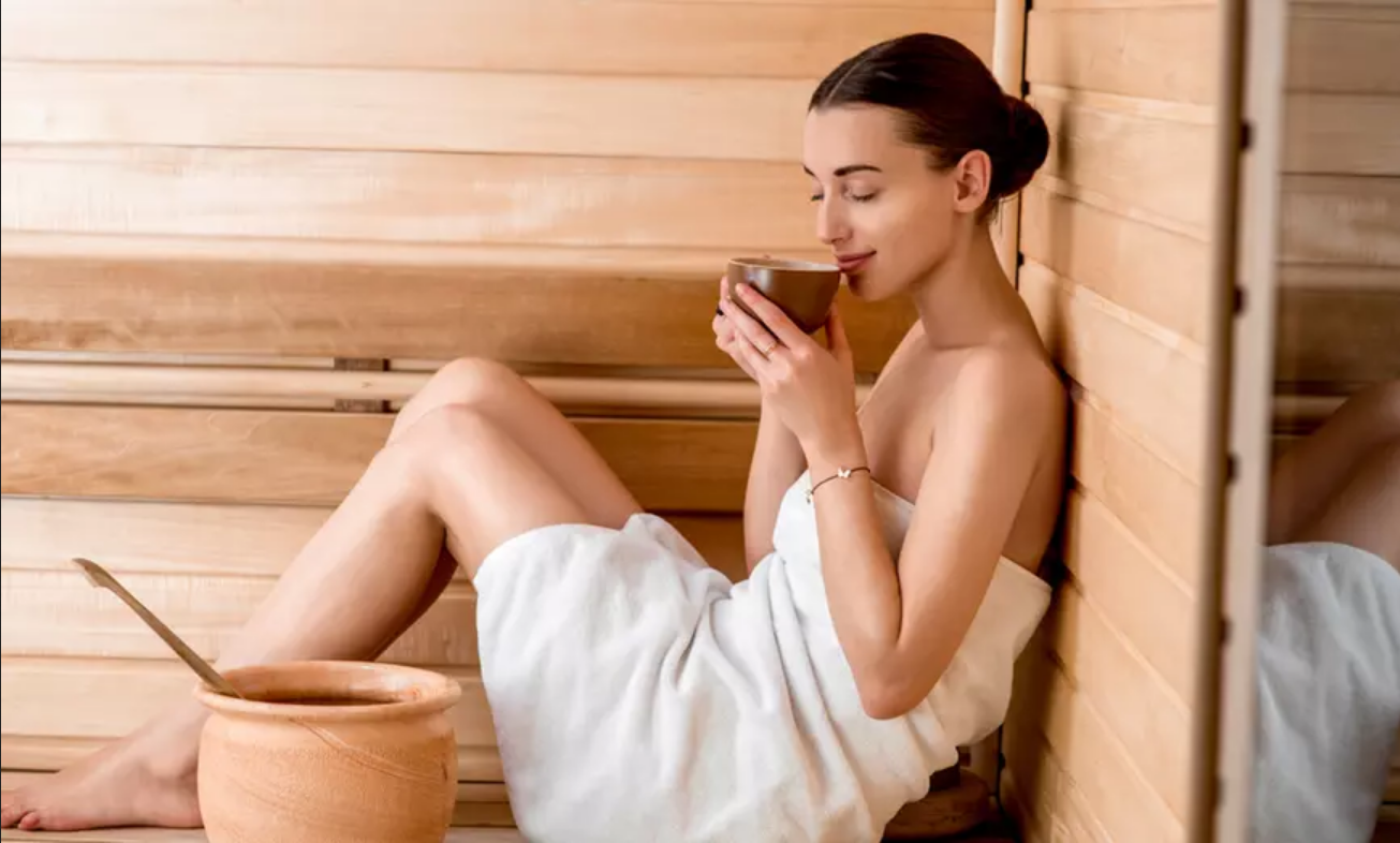 Een vrouw drinkt thee in een sauna.