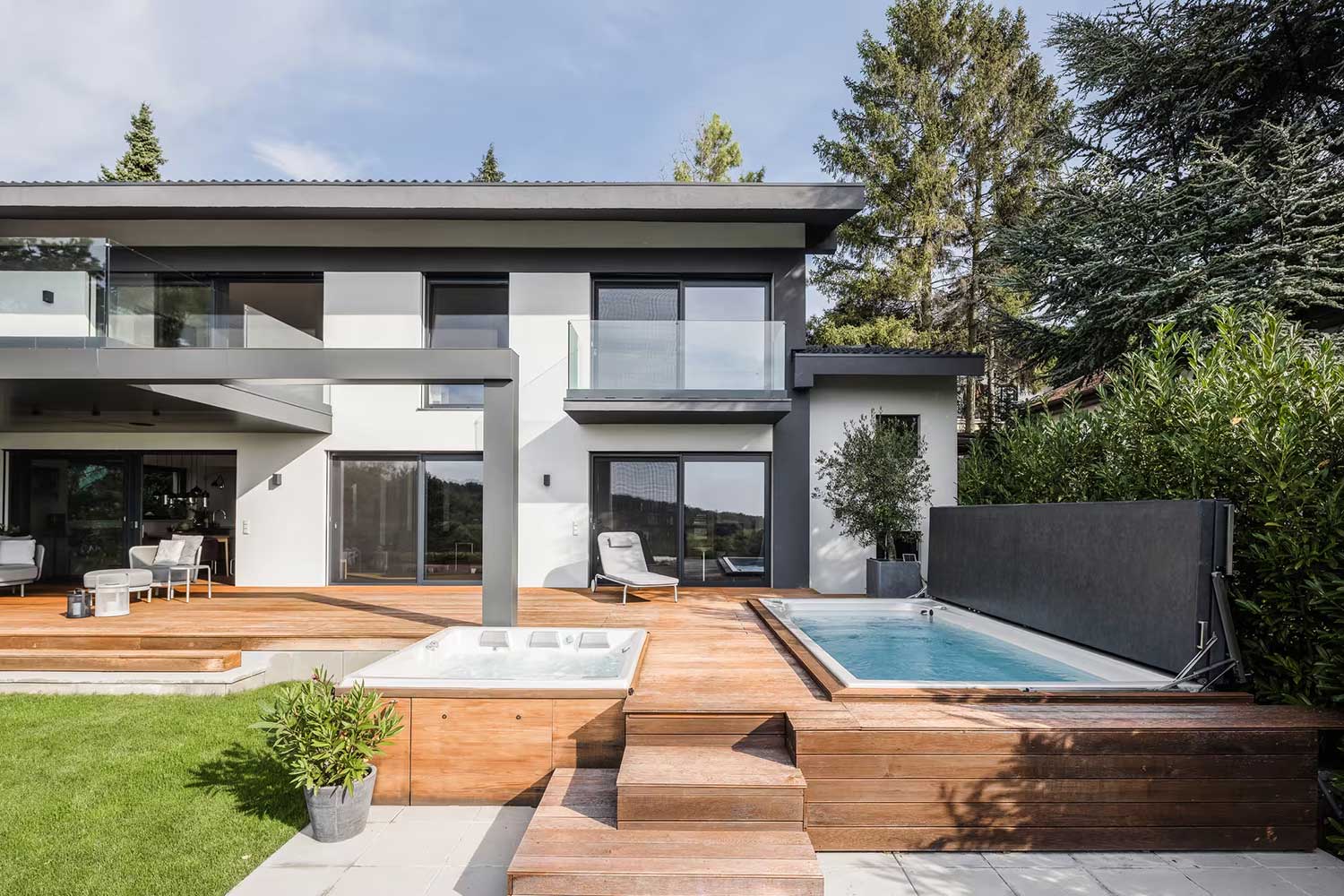 USSPA spa- en zwemspabaden met verhoogde afdekkingen, geïnstalleerd naast het terras van een modern huis.