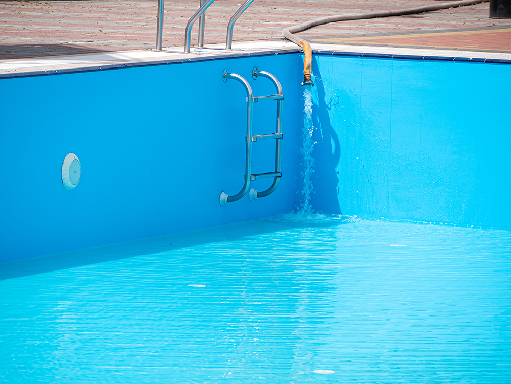 Het vullen van een buitenzwembad met water.