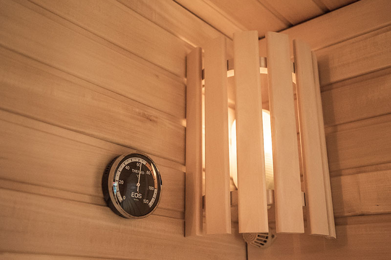 EOS saunathermometer en houten lampenkap in de hoek.