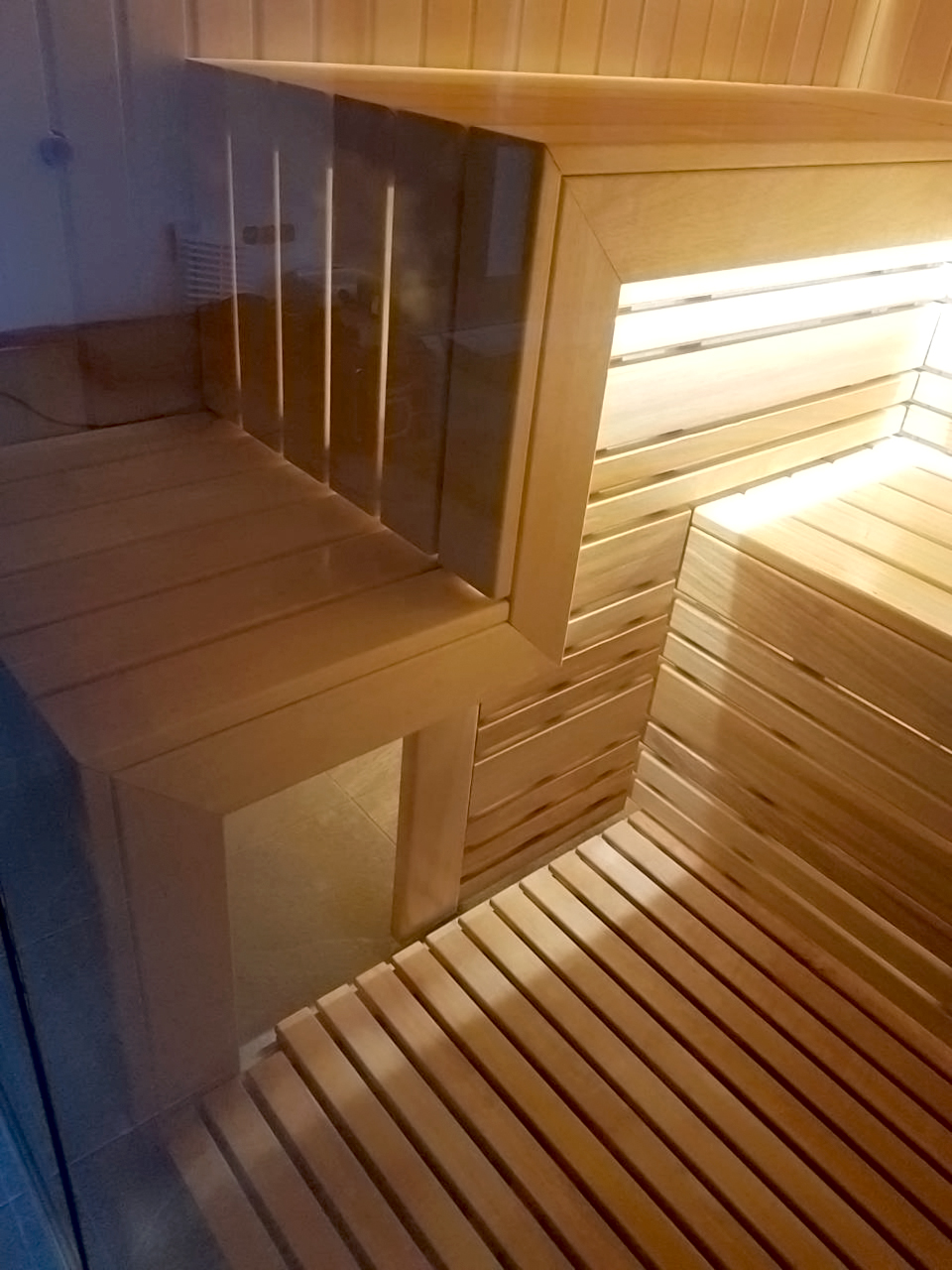 Sauna met glazen wanden en uitzicht op het zwembad