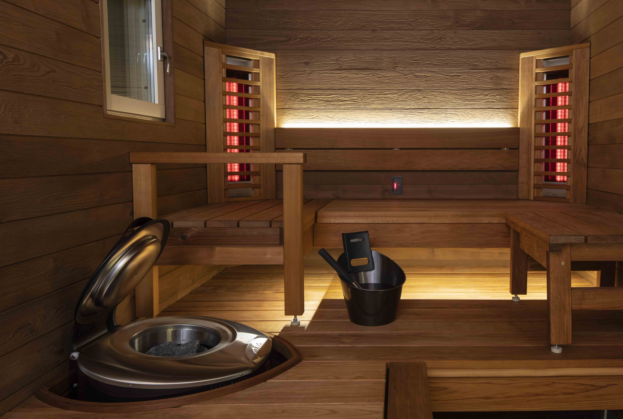 Infraroodsauna met houten banken, verwarmingselementen en een kachel voor ontspanning en welzijn.