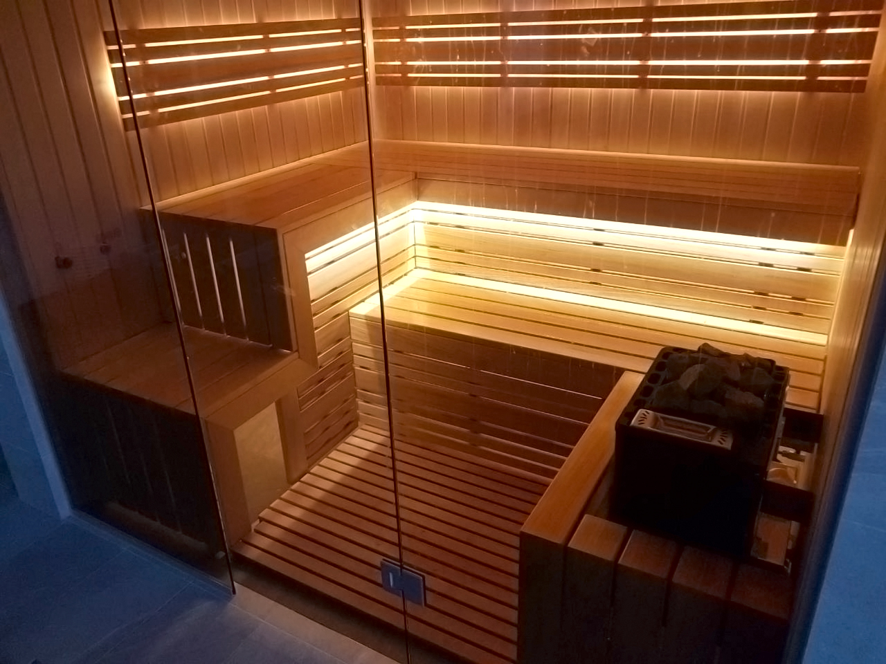Sauna met glazen wanden en uitzicht op het zwembad